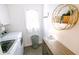 Bright laundry room with a window, decorative wall shelf, cabinet, clothes hamper, and washer dryer at 6379 Monitor Dr, Indianapolis, IN 46220