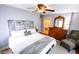 Inviting main bedroom with decorative headboard, ceiling fan, and wooden dresser with mirror at 6379 Monitor Dr, Indianapolis, IN 46220