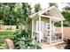 Charming outbuilding with a white porch, decorative railing, and well manicured landscaping at 6379 Monitor Dr, Indianapolis, IN 46220