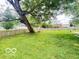 Expansive backyard with mature tree coverage, a grassy lawn, and a classic wooden fence at 6546 Derbyshire Rd, Indianapolis, IN 46227
