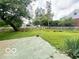 Spacious backyard featuring a patio, grassy lawn, mature trees and a charming wooden fence at 6546 Derbyshire Rd, Indianapolis, IN 46227