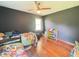 Bedroom with twin beds, hardwood floors, ceiling fan, closet, and window with natural light at 6546 Derbyshire Rd, Indianapolis, IN 46227
