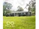 Charming single-story home with a well-manicured lawn and mature trees providing shade at 6546 Derbyshire Rd, Indianapolis, IN 46227