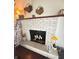 Cozy living room featuring a painted brick fireplace with decorative accents and hardwood floors at 6546 Derbyshire Rd, Indianapolis, IN 46227