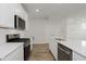 Modern kitchen with stainless appliances, black gas range, and sleek white cabinetry at 7282 Shroyer Way, Noblesville, IN 46062