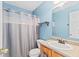 Blue bathroom with a toilet, shower with curtain, sink and vanity at 772 Cembra Dr, Greenwood, IN 46143