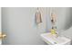 Half bathroom with modern sink, gold faucet and light-blue wall at 772 Cembra Dr, Greenwood, IN 46143