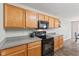Kitchen showcasing wood cabinets, black appliances, gray countertops, and modern fixtures at 772 Cembra Dr, Greenwood, IN 46143