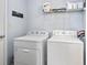 Bright laundry room with white appliances, shelves and 'Welcome' sign at 772 Cembra Dr, Greenwood, IN 46143