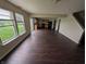 Large, open-concept area with hardwood floors, plenty of natural light, and a view into the kitchen at 908 Belvedere Dr, Shelbyville, IN 46176