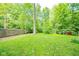 Spacious backyard featuring a lush green lawn, mature trees, and a wooden fence providing privacy for outdoor enjoyment at 10104 Sycamore Ln, Indianapolis, IN 46239