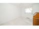 Bright bedroom featuring a window, white walls, light carpet, and a wooden cabinet at 10104 Sycamore Ln, Indianapolis, IN 46239
