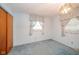 This carpeted bedroom offers natural light from curtained windows and a closet for storage at 10104 Sycamore Ln, Indianapolis, IN 46239