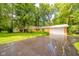 Inviting single-story home with a brick front, attached garage and an expansive driveway, set amongst mature trees at 10104 Sycamore Ln, Indianapolis, IN 46239