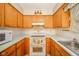 Traditional style kitchen with wood cabinets and white appliances at 10104 Sycamore Ln, Indianapolis, IN 46239
