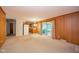 Open floor plan with hardwood-look paneling and sliding glass doors to porch at 10104 Sycamore Ln, Indianapolis, IN 46239