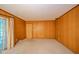 Cozy living room with paneled walls and access to the outdoor porch at 10104 Sycamore Ln, Indianapolis, IN 46239