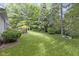 Expansive backyard with a well-manicured lawn, lush greenery, and a wooden deck ideal for outdoor activities at 1114 Clairborne Ct, Indianapolis, IN 46280