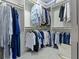 Walk-in closet with ample hanging space, a variety of clothing items, and a plush white carpet at 1114 Clairborne Ct, Indianapolis, IN 46280