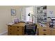 Well-lit home office with a spacious desk, built-in shelves, and a view of the adjoining room at 1114 Clairborne Ct, Indianapolis, IN 46280