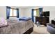 This bedroom has plush carpeting, two windows with blue curtains and a television on a dresser at 13151 W Youth Camp Rd, Columbus, IN 47201