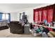 View of a bedroom with plush carpets, red curtains and a cluttered table next to a recliner chair at 13151 W Youth Camp Rd, Columbus, IN 47201