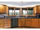 Well-lit kitchen features wood cabinets, modern appliances, dark countertops, and a sink with a window view at 13151 W Youth Camp Rd, Columbus, IN 47201