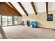 Spacious living area offers vaulted ceilings, exposed beams, and a patio entrance at 13151 W Youth Camp Rd, Columbus, IN 47201