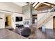 Spacious living room featuring a stone fireplace, stairs, and wood floors at 13151 W Youth Camp Rd, Columbus, IN 47201