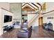 Spacious living room featuring a stone fireplace, stairs, and wood floors at 13151 W Youth Camp Rd, Columbus, IN 47201