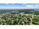 Expansive aerial view of the neighborhood featuring lush trees, well-maintained homes, and community spaces under a bright, cloudy sky at 1420 E Loretta Dr, Indianapolis, IN 46227