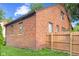 View of the brick exterior of the home, showcasing multiple windows, a well-kept lawn, and a wooden privacy fence at 1420 E Loretta Dr, Indianapolis, IN 46227