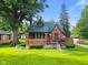 Brick home with a charming front exterior, featuring a well-manicured lawn, mature trees, and inviting curb appeal at 1420 E Loretta Dr, Indianapolis, IN 46227