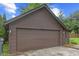 Exterior of the large detached garage with a brown painted exterior, concrete driveway, and attached wooden deck at 1420 E Loretta Dr, Indianapolis, IN 46227