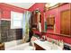 Bathroom features a shower/tub, a sink, and a large mirror with red walls at 2029 N Colorado Ave, Indianapolis, IN 46218