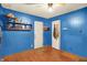 Bedroom features blue walls, wood floors, and multiple white doors at 2029 N Colorado Ave, Indianapolis, IN 46218