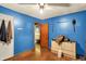 This cozy bedroom features cool blue walls, ceiling fan, and original hardwood floors at 2029 N Colorado Ave, Indianapolis, IN 46218