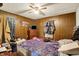 Bedroom features wood paneled walls, a ceiling fan, and a window with patterned curtains at 2029 N Colorado Ave, Indianapolis, IN 46218