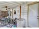 Enclosed white patio has a fan, dining table, refrigerator and indoor outdoor carpet at 2029 N Colorado Ave, Indianapolis, IN 46218