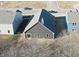 Aerial view showcasing a newly constructed home with a gray roof, surrounded by a landscaped yard in a residential community at 2057 Abbey Ln, Columbus, IN 47201