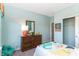 Bright and cheerful bedroom with dinosaur themed bedding, dresser with mirror, and plenty of natural light at 2057 Abbey Ln, Columbus, IN 47201