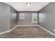 Minimalist bedroom featuring two windows bringing in light and wood look flooring at 20846 Winding Lake E Dr, Noblesville, IN 46062