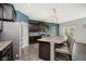 Bright kitchen featuring a large island with seating, stainless steel appliances, and dark wood cabinets at 20846 Winding Lake E Dr, Noblesville, IN 46062