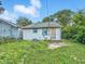 Backyard view of house with siding, green lawn, overgrown foliage, and fence at 2426 Lasalle St, Indianapolis, IN 46218