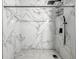 Stylish shower featuring marble-patterned walls and tiled flooring, complete with modern fixtures and a convenient storage rack at 2426 Lasalle St, Indianapolis, IN 46218