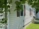 A partial side view of the home showing neutral-colored siding and lush, green landscaping at 249 Ohio St, Franklin, IN 46131