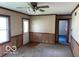 An empty living room featuring carpet, wainscotting, ceiling fan, windows, and doorway at 249 Ohio St, Franklin, IN 46131