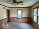 An empty living room featuring carpet, wainscotting, ceiling fan and large windows at 249 Ohio St, Franklin, IN 46131