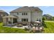 Spacious backyard featuring a patio with a dining set, seating and a fire pit surrounded by lush landscaping at 2566 Maple Creek Dr, Westfield, IN 46074