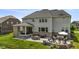 Charming backyard featuring a stone fire pit with seating, a dining area, and covered patio with outdoor furniture at 2566 Maple Creek Dr, Westfield, IN 46074
